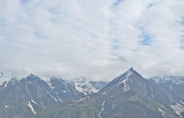 Fototapeta premium Leh Mountain Peaks Shrouded in Clouds under Clear Blue Sky