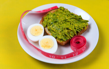 Food for weight loss. Egg, avocado, toast, meter. Cooking healthy food at home. Food on a yellow background.