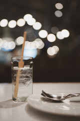 A glass with ice on a bokeh background.