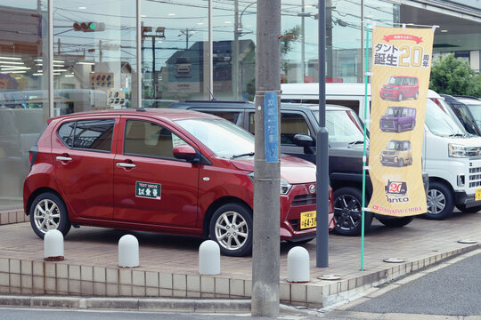 CHIBA, JAPAN - June 20, 2024: Cars, including a Mira e:s for test driving in front of a Daihatsu car showroom in Chiba City.