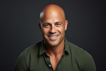 Fototapeta premium Portrait of a smiling mature man in a green shirt over dark background.