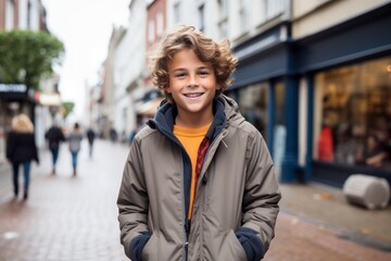 Fototapeta premium Portrait of a handsome young boy with curly hair in a city street
