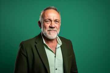 Fototapeta premium Portrait of a senior man on a green background. Studio shot.
