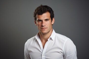 Obraz premium Portrait of handsome young man in white shirt on grey background.