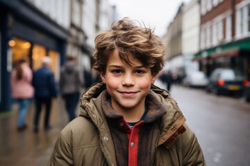 Fototapeta premium Portrait of a cute little boy in the city. Shallow depth of field