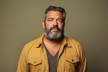Obraz premium Portrait of a bearded man in a yellow jacket on a green background