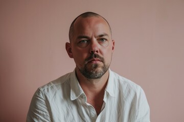 Obraz premium Portrait of a man in a white shirt on a pink background