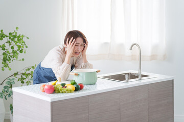 料理に失敗して落ち込む女性（キッチン・主婦）