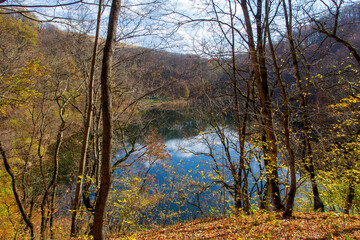 autumn day on a mountain lake of karst origin surrounded by a yellowing forest