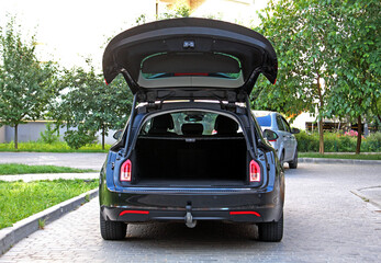 Black Car trunk. Rear view of the car open trunk. Wagon car trunk open. Modern vehicle have an open trunk. The car boot is open and ready for luggage loading.  © Best Auto Photo