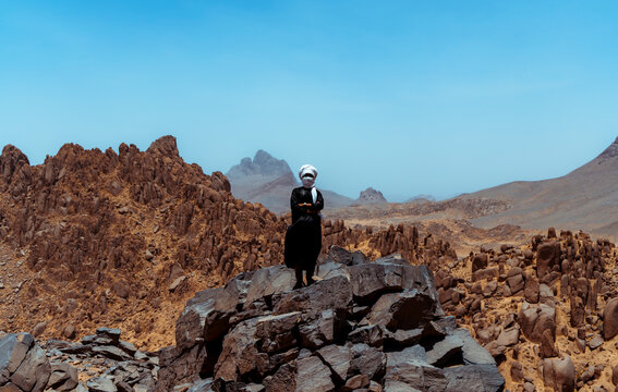Guy from the desert standing on the top of a mountain 
