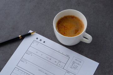 コーヒーを飲みながら、履歴書を書く
