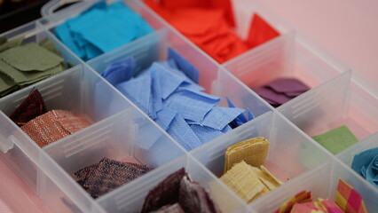 Various colors of patchwork pieces in a plastic box