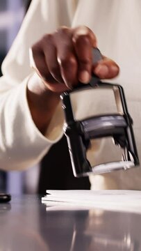 Businesswoman Notarizing Documents With Stamp
