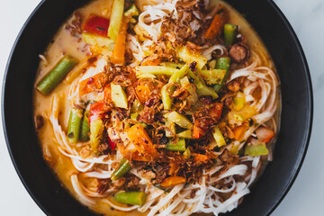 plant-based dan dan rice noodles soup with mixed vegetables and spicy sauce