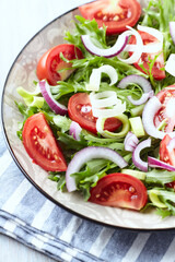 Salad with fresh tomatoes and arugula on a bright background. Close up.	