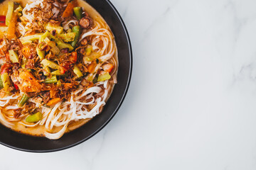 plant-based dan dan rice noodles soup with mixed vegetables and spicy sauce