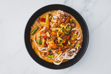 plant-based dan dan rice noodles soup with mixed vegetables and spicy sauce