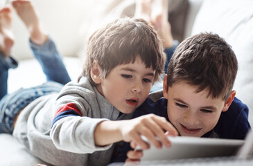 Family, children and siblings with tablet on sofa for movie, search or gaming while bonding in their home together. Digital, love and boy kids in living room with elearning, ebook or storytelling app