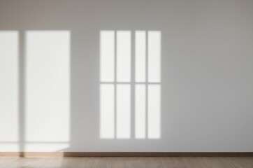 Sun casts light shadow patterns on empty room from window onto white wall