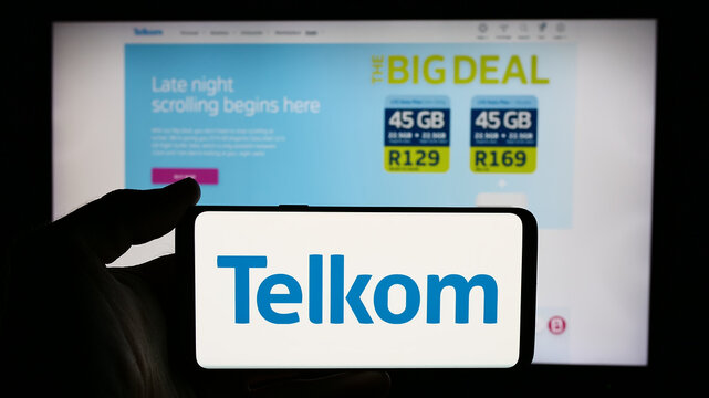 Stuttgart, Germany - 06-11-2024: Person holding mobile phone with logo of South African company Telkom SA SOC Limited in front of business web page. Focus on phone display.