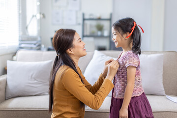 Happy cheerful Asian family living together in a weekend, woman asian embracing her lovely little daughter and smiling to camera. Modern asian lifestyles concept.