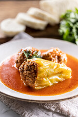 Stuffed green pepper with meat balls in tomato sauce, sourdough dumpling in the background