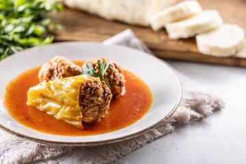 Stuffed green pepper with meat balls in tomato sauce, sourdough dumpling in the background