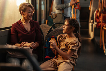 Fototapeta premium Child talking to a short-haired woman on a bus