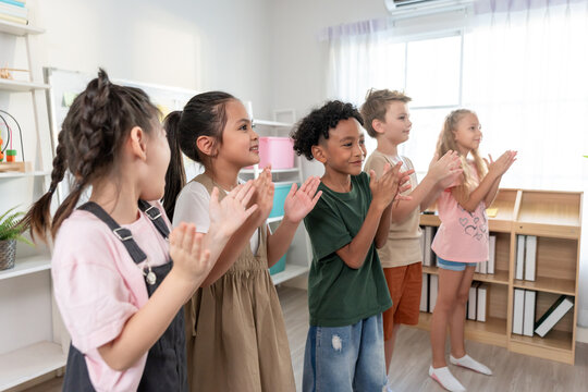 Group of diversity adorable student clapping hands at nursery school.