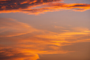 Dramatic sunset or sunrise scene. Pink and purple summer clouds against blue sky