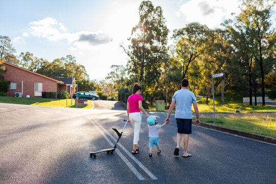 Family crossing road while going on walk together in suburban area