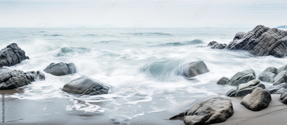 Aufkleber seaside scene with gray rocks amidst the sea and white foamy waves along the shore creating a tranqu