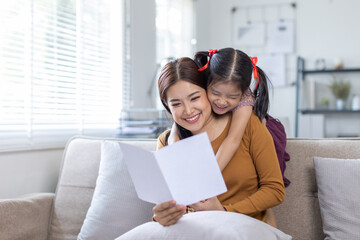 cheerful asian toddler daughter hugging happy mother Good time at home.