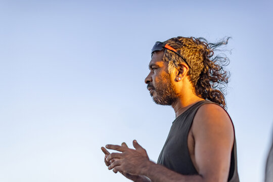 upper body of proud aboriginal man in profile against a clear blue sky