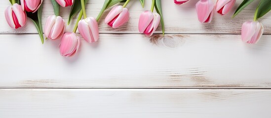 Valentine's Day-themed wooden white background adorned with pink tulips, hearts, and a copy space image for text.