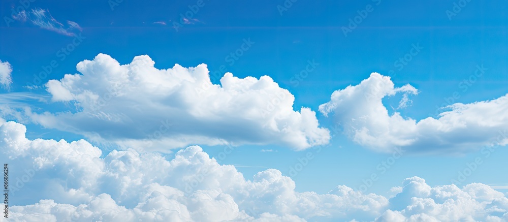 Poster the expansive blue sky filled with fluffy white clouds creates a serene copy space image.