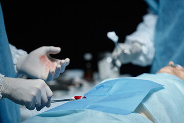 Close up of surgeon performing surgery on unrecognizable patient in operating room copy space