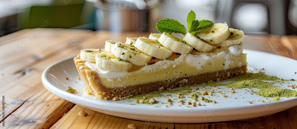 Poster banana-topped matcha banoffee pie on a white plate with a wooden table backdrop for a copy space ima
