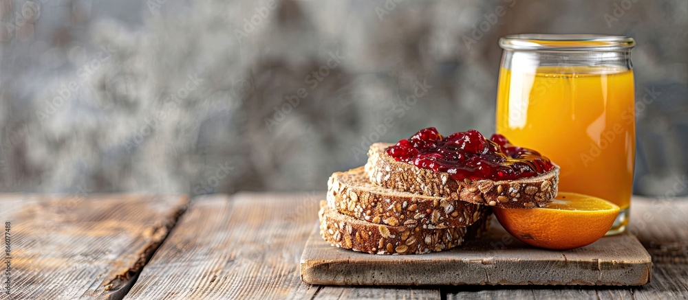 Poster Whole grain bread with mixed berry jam, accompanied by orange juice in a glass on a wooden backdrop, creating a relaxing scene with copy space image.