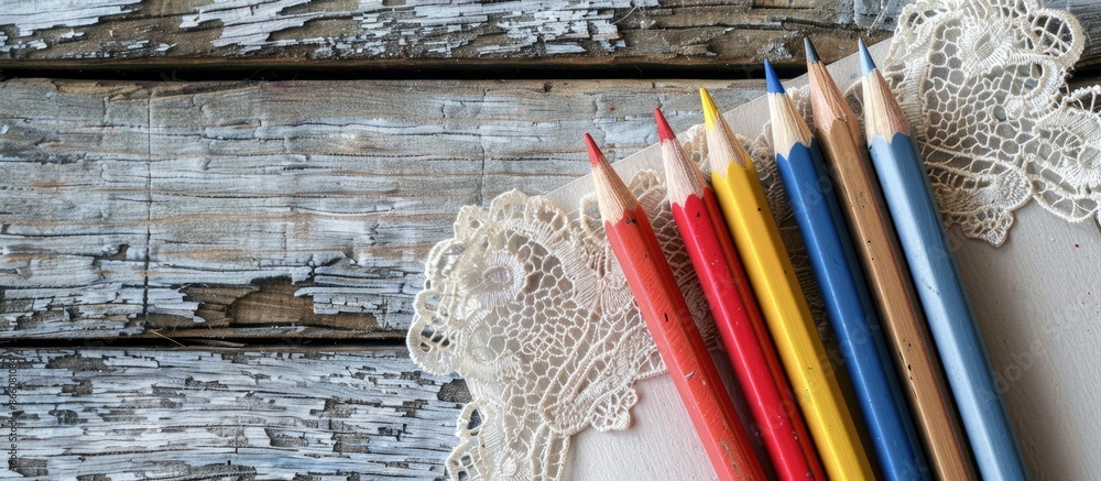 Poster notebook with lace, pencils on wood background with copy space image.