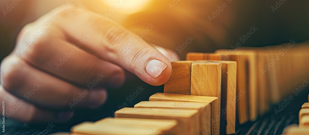 Aufkleber Close-up shot of a retro-style hand holding a wooden domino, symbolizing a solution and domino effect with a slightly blurred background. Ample copy space for text or images.