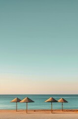 Fototapeta premium Two Yellow Umbrellas on a Beach With Blue Sky and White Clouds