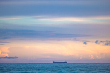Cargo ship lined up at sea en route to Newcastle Harbour under a vibrant sunset sky