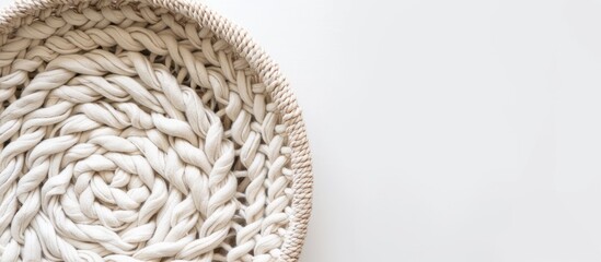 A top view photo of a handmade macrame basket featuring intricate braiding with cotton threads on a white backdrop. Perfect light image for macrame and crafts promotions with copy space.
