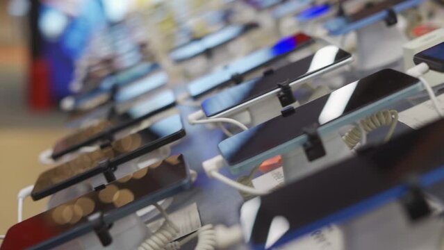 A lot of smartphone models on display at the exhibition stand of an electronics store