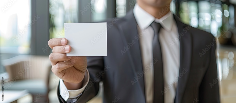 Aufkleber a businessman displaying a white business card in an office setting with copy space image available.