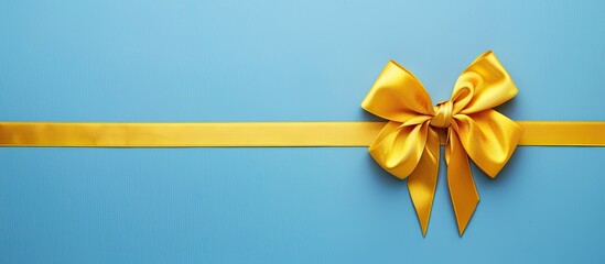 Flat lay image featuring a gold ribbon and yellow bow from a top view, isolated on a colored background with space for additional text or elements.
