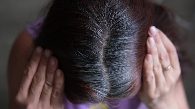 HD video. Gray hair on the head of a mature woman. Long gray hair. The initial stage of gray hair. The problem of gray hair in women. Taken from above.