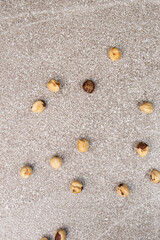 Roasted hazelnuts on a gray stone background top view.